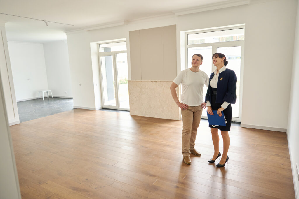 A female real estate agent shows a client around a new home that's been fixed up by AEB Services, Inc.